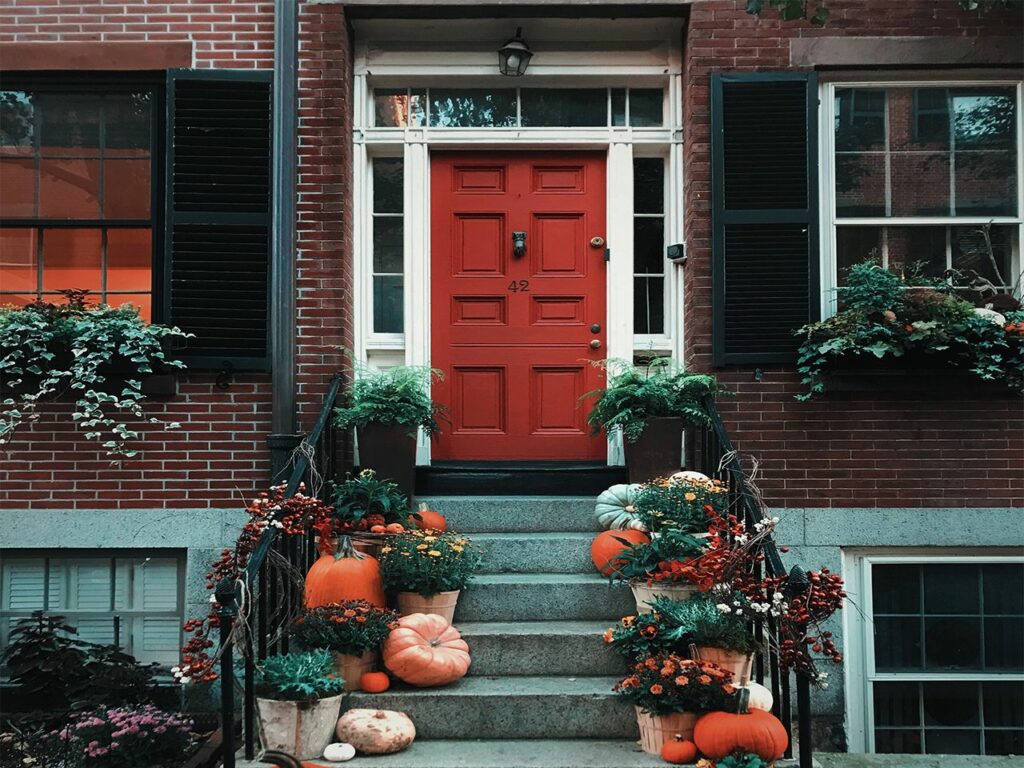 A beautiful entrance of a house decorated with pumpkins for halloween.